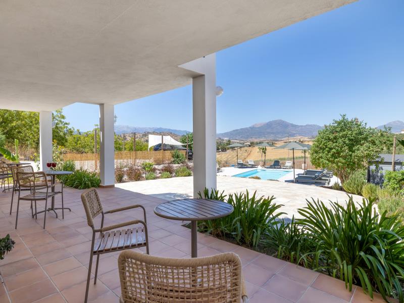 Terrace with several seating spots overlooking the pool and mountains