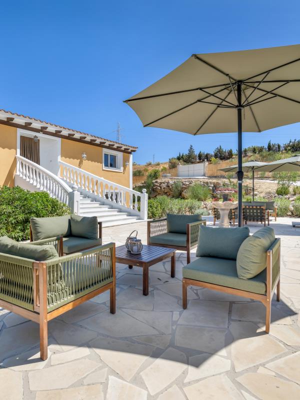 Lounge corner with woven armchairs and parasol on the terrace