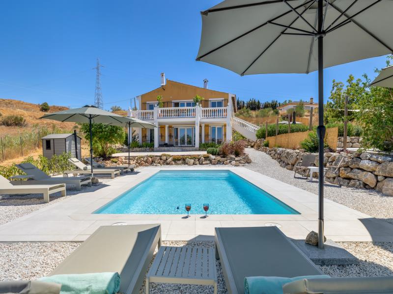 Pool with a view of the villa's white balustrade and balcony