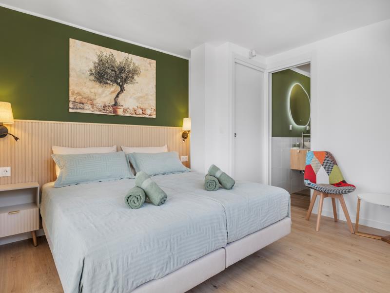 Room 1 with olive-tree painting and view through to the en-suite bathroom