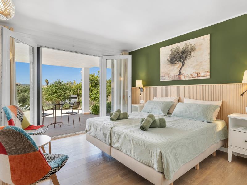 Room 2 bedroom with patchwork armchairs and open terrace doors