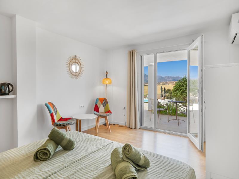 Seating corner in room 3 with patchwork chairs and pool view